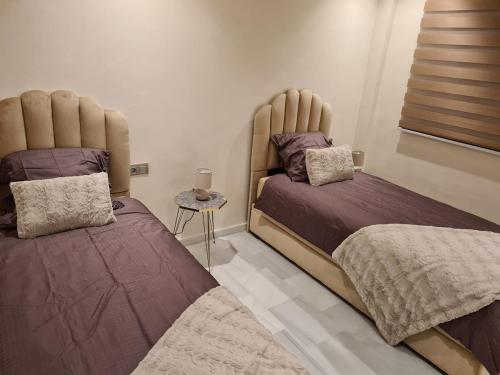 two beds sitting next to each other in a bedroom at Appartement sur la corniche 2 chambres in Tangier