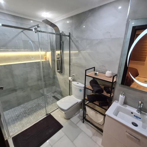 a bathroom with a shower and a toilet and a sink at Appartement sur la corniche 2 chambres in Tangier