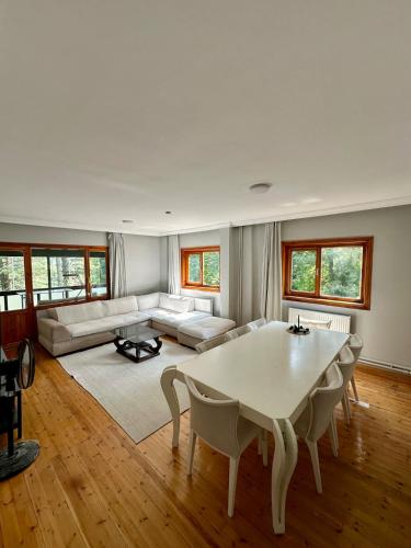 a living room with a table and a couch at Sapanca Orman İçinde Özel Havuzlu Villa in Sakarya