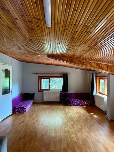 a large room with purple couches and a wooden ceiling at Sapanca Orman İçinde Özel Havuzlu Villa in Sakarya