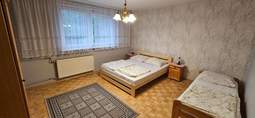a small bedroom with two beds and a table at Pod Dębami in Wadowice