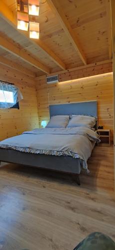 a bed in a room with a wooden ceiling at Domek nad jeziorem Giżyno - cisza i natura Piotiwo D1 in Kalisz Pomorski