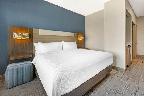 a bedroom with a large bed and a blue wall at Holiday Inn Express Hotel & Suites Astoria by IHG in Astoria, Oregon