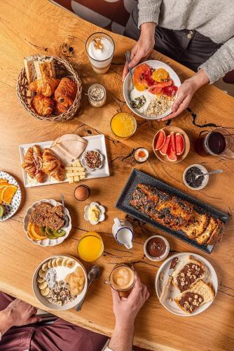 a wooden table with plates of food on it at Ibis Saint Étienne - La Terrasse in Saint-Étienne