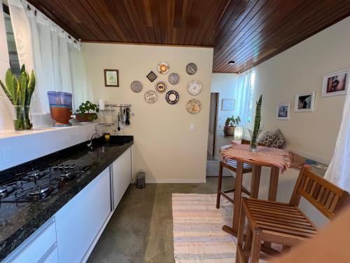 a kitchen with white cabinets and a table and a counter at Pariká Pousada in Alto Paraíso de Goiás