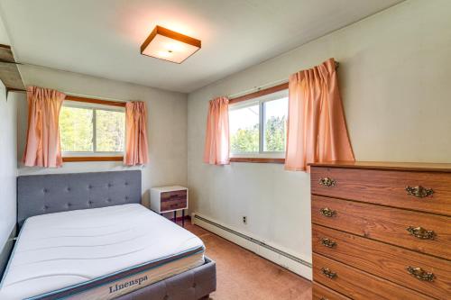 a bedroom with a bed and a dresser and two windows at Fishers Retreat Hayward Home, Near ATV Trails! in Seeley