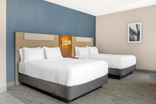 two beds in a hotel room with white pillows at Holiday Inn Express Hotel & Suites Astoria by IHG in Astoria, Oregon