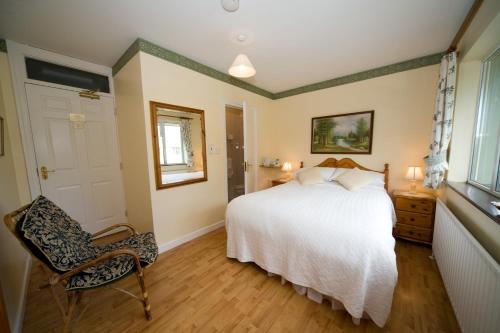 1 dormitorio con 1 cama blanca y 1 silla en Danabel B&B en Kinsale