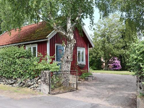 a red house with a tree in front of it at 4 person holiday home in STENINGE in Steninge