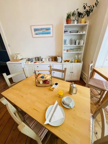 a wooden table with plates on it in a kitchen at The Tremont in Penzance