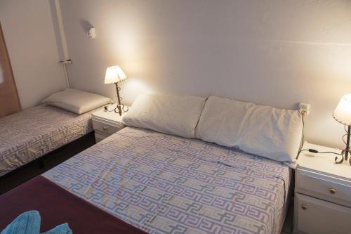 a small room with two beds and two lamps at Hostel Pituco - En el corazón de la ciudad in Mendoza