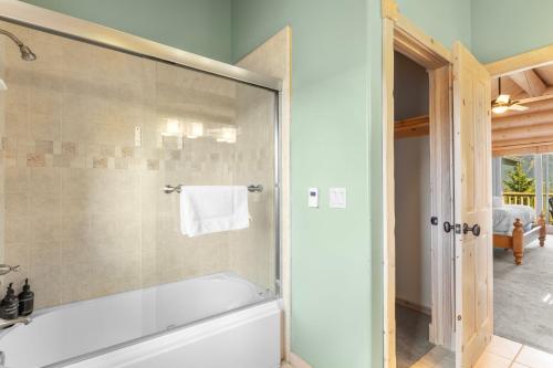 a bathroom with a tub and a glass shower at Hot Tub Game Room Large Deck w Incredible View Penticton Lodge by AvantStay in Big Bear Lake