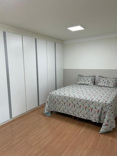 a bedroom with a bed in a room with white cabinets at Apartamento Praça Inconfidência Bom Despacho in Bom Despacho