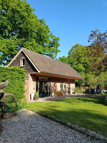a stone house with a garden and a lawn at Vakantiewoning met hottub en bedstede - De Kruidenhoeve in het Reestdal in Balkbrug