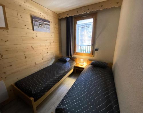 une chambre avec deux lits et une fenêtre dans l'établissement Résidence Cristallin - Le Cristallin 30 - Beau 2 pièces au pied des pistes MAE-4764, à Valmorel