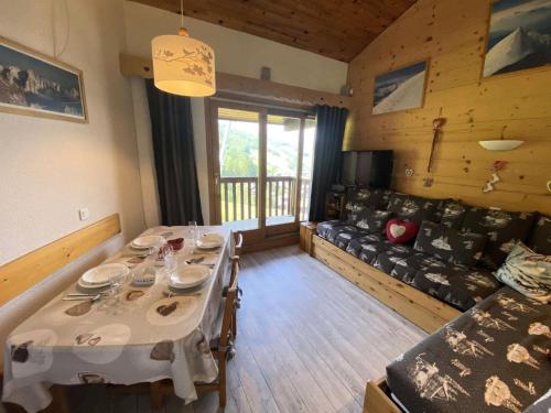 une salle à manger avec une table et un canapé dans l'établissement Résidence Cristallin - Le Cristallin 30 - Beau 2 pièces au pied des pistes MAE-4764, à Valmorel