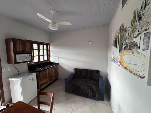 a small kitchen with a chair and a refrigerator at Villa Cavaliere in Palhoça
