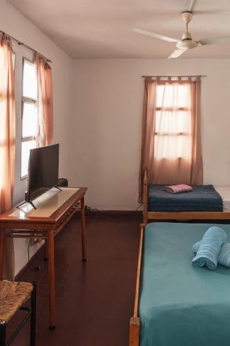a room with a desk with a computer and a bed at Hostel Pituco - En el corazón de la ciudad in Mendoza