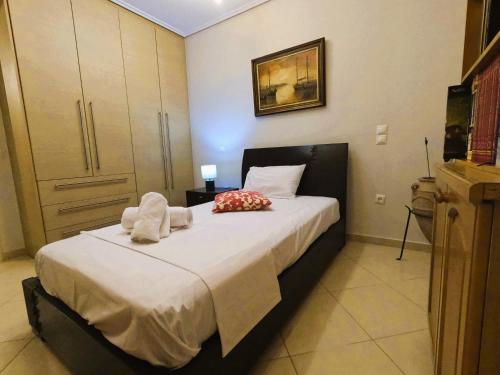 a bedroom with a bed with towels on it at Stylish 2BR Semi-Basement- Cozy & Family-Friendly Retreat in Loutraki