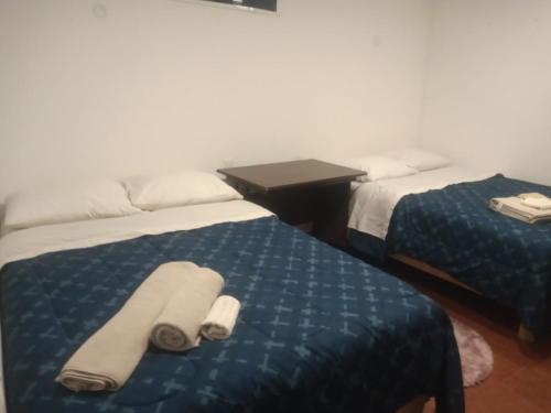 two beds in a hotel room with towels on them at Posada Las vigas in Zacatlán