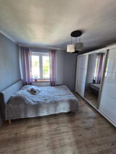 a bedroom with a bed and a large window at Między Szczytami in Nowa Ruda