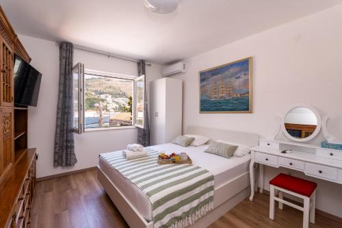 a bedroom with a bed and a desk and a window at APARTMENT LEA BAYVIEW in Dubrovnik