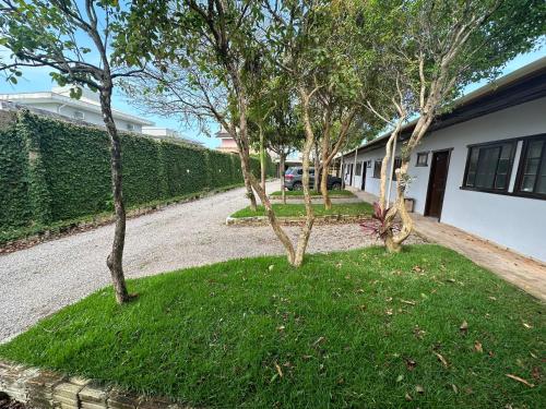 a row of trees in a yard next to a house at Villa Cavaliere in Palhoça