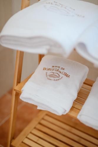 a pillow with the words just on nationality sits on a stool at Monte da Boavista de Cima - Casa de Campo