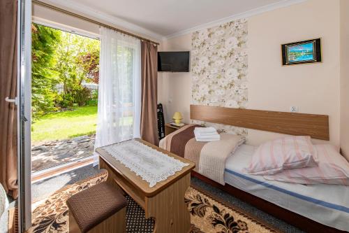a bedroom with a bed and a sliding glass door at O. W. Jodełka in Łeba