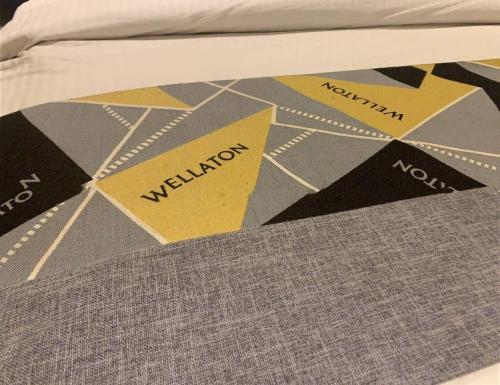 a bed with a comforter with the words vacation on it at Wellaton Suites in Abuja