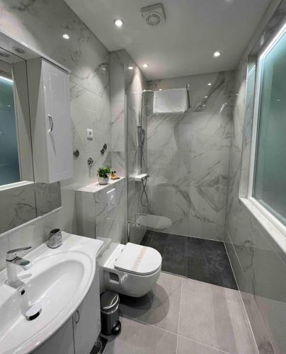 a bathroom with a sink and a toilet and a shower at VILLA Juky in Kaštela