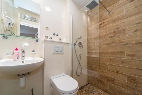 a bathroom with a shower and a toilet and a sink at Villa Tomislav in Baška Voda