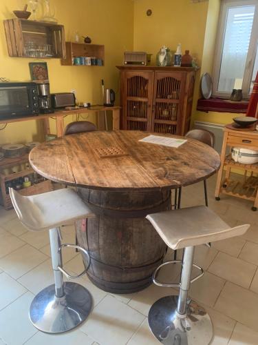 une cuisine avec une table en tonneaux de vin dans l'établissement Maison de village, à Belvès