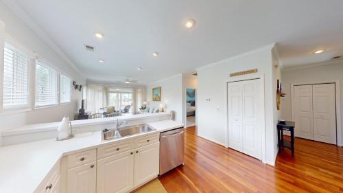 a kitchen with white walls and wooden floors at Lake Views, 2BR, 2BA, Lakeside Villa in Pawleys Island