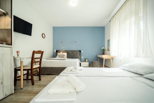 1 Schlafzimmer mit 2 Betten, einem Tisch und einem Schreibtisch in der Unterkunft Seaside Studio in Nea Peramos, Sleeps 4 in Néa Péramos