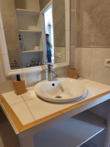 un homme prenant une photo d'un lavabo dans la salle de bains dans l'établissement le Balcon de la Savasse, à La Celle-sous-Gouzon