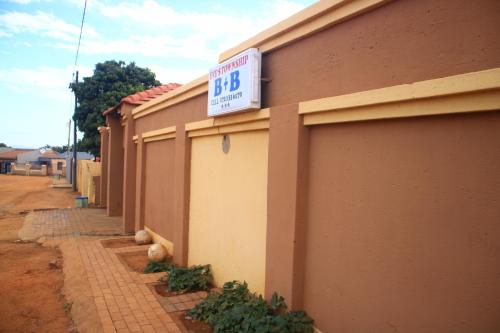 a building with a sign on the side of it at EvehomeStay B&B in Soshanguve