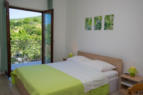 a bedroom with a bed and a large window at Apartments Adriana in Klenovica