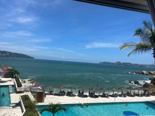 a view of the ocean from a resort with a swimming pool at Suite para 4 personas in Acapulco