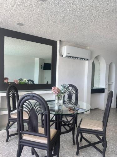 a dining room with a table and chairs and a mirror at Suite para 4 personas in Acapulco