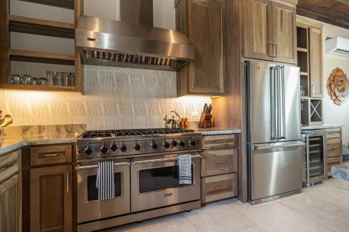 a kitchen with a stainless steel stove and refrigerator at Prana Maya Island Resort in Placencia Village