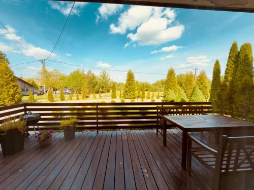 a wooden deck with a table and bench on it at Apartament u kucharzy Łysica 1 in Wilków