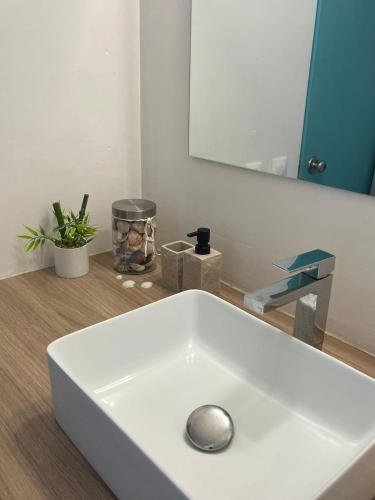 a white sink in a bathroom with a mirror at Diamant Bleu studio, piscine, vue mer in Le Diamant