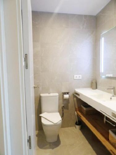 a bathroom with a toilet and a sink at Can Isabel, apartamento con piscina, restaurante y zona de juegos in Cala en Porter