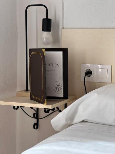 a book sitting on a shelf next to a bed at Casa Cardona in Móra d'Ebre