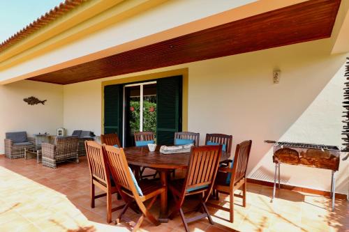 a dining room with a wooden table and chairs at Casa das Ondas by AnaLodges in Porto Santo