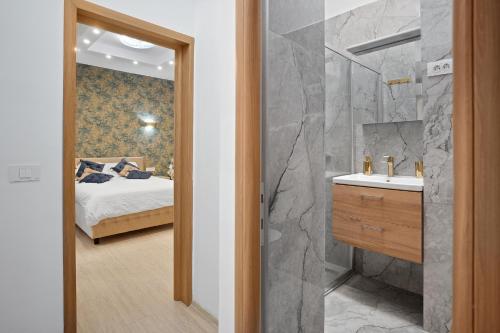 a bathroom with a bed and a sink and a mirror at Victoriei Avenue Gem in Bucharest