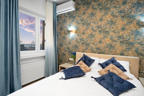 a bedroom with a bed with blue pillows on it at Victoriei Avenue Gem in Bucharest