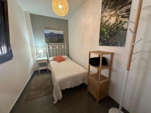 a small bedroom with a bed and a shelf at El Retiro de Casa Nieves in Villahermosa del Río