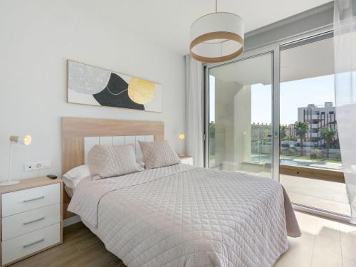 Un dormitorio con una cama y una ventana grande. en Ema Residencial, en Villamartin